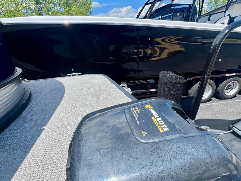 Slide: The Image of 2022 Manitou 25 LX SHP DE boat with Minn Kota motor, parked on a trailer. - 8