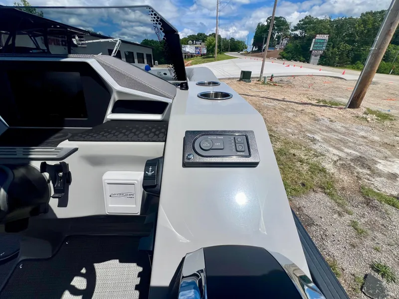 Slide: The Image of 2022 Manitou 25 LX SHP DE boat dashboard with control panel and cup holders. - 9