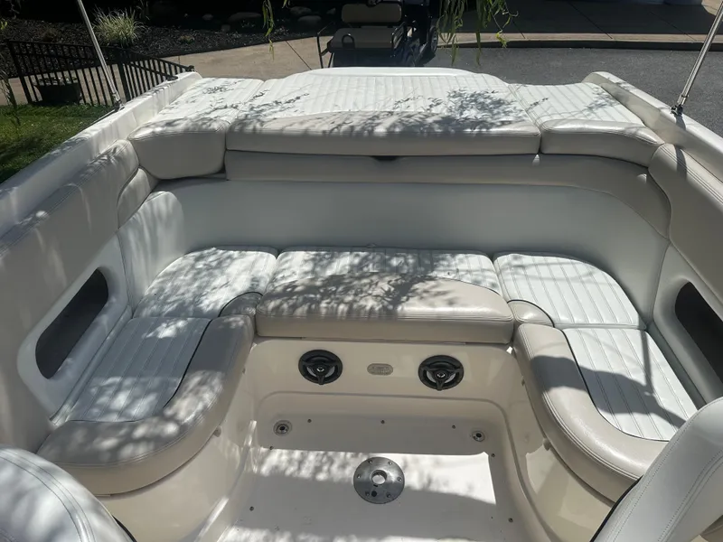 Slide: The Image of 2007 Bryant 240BR boat interior with white cushioned seating and speaker system. - 2