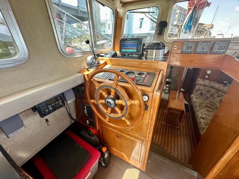 Slide: The Image of Interior of 1985 Fisher 34 Pilothouse Ketch with wooden helm and navigation equipment. - 11