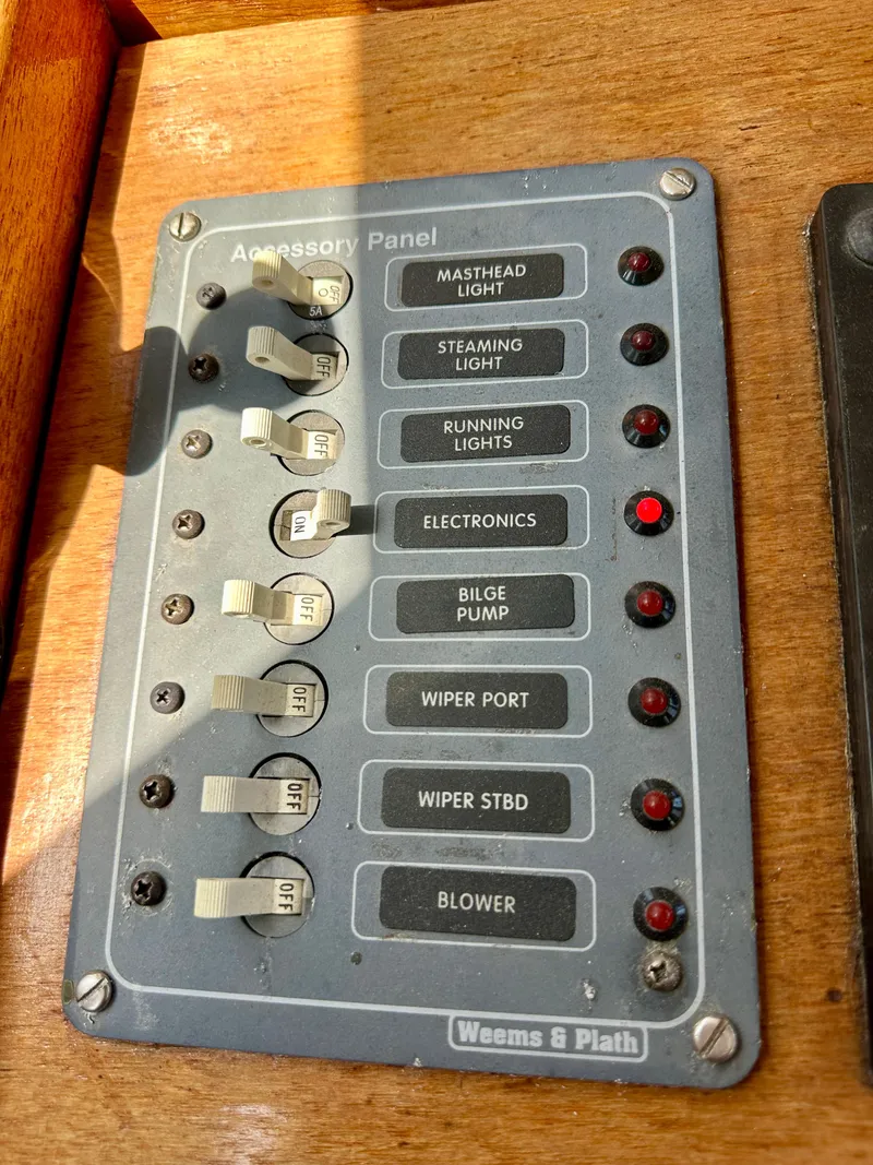 Slide: The Image of Control panel on 1985 Fisher 34 Pilothouse Ketch with labeled switches and indicators. - 24