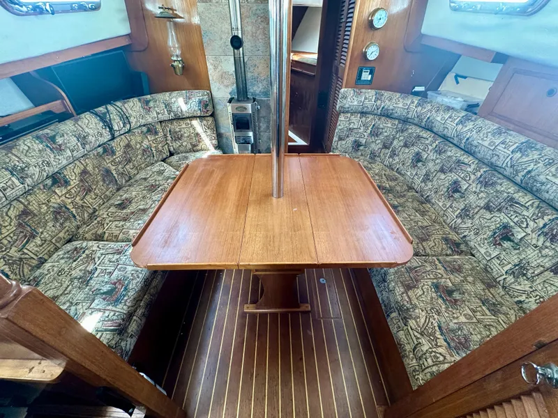 Slide: The Image of 1985 Fisher 34 Pilothouse Ketch interior with wooden table and patterned seating. - 34