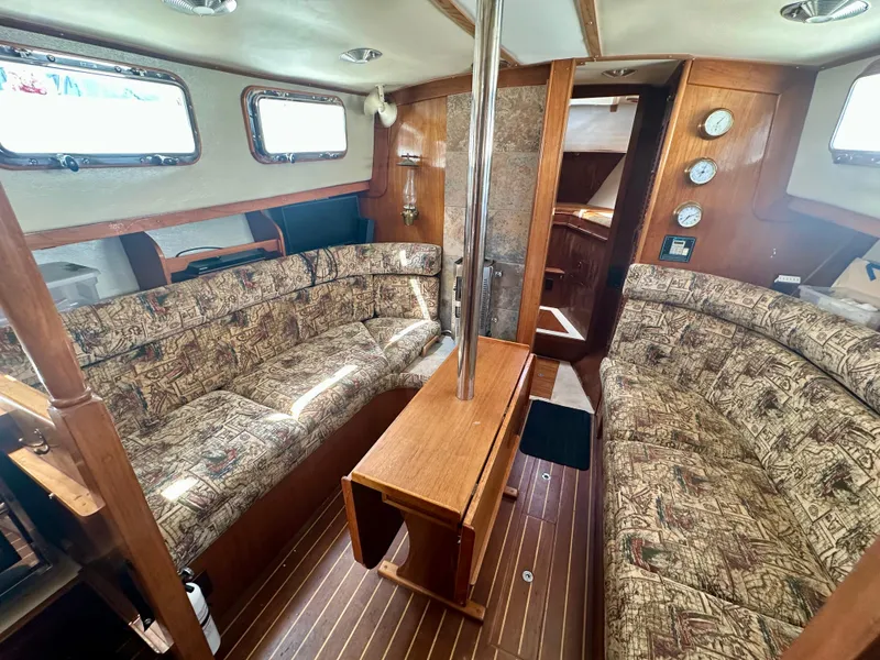 Slide: The Image of Interior of 1985 Fisher 34 Pilothouse Ketch with wood paneling and patterned seating. - 37