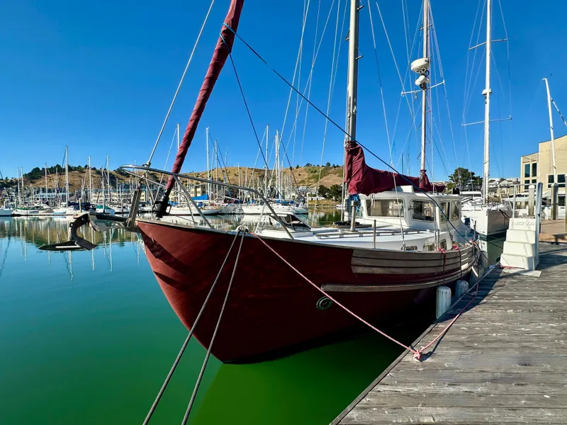 Slide: The Image of 1985 Fisher 34 Pilothouse Ketch docked in a serene marina setting. - 4