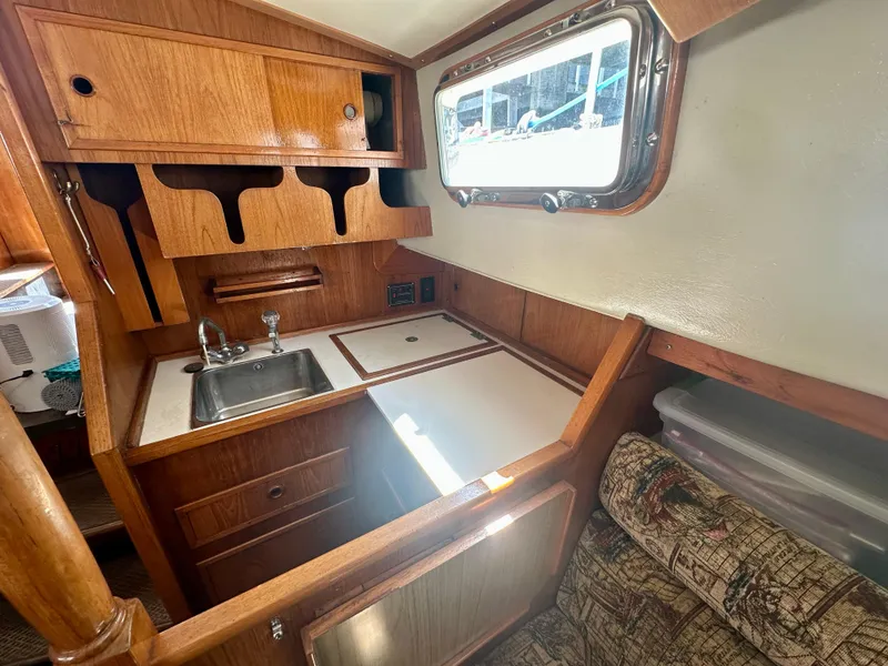 Slide: The Image of 1985 Fisher 34 Pilothouse Ketch interior galley with wooden cabinetry and sink. - 41
