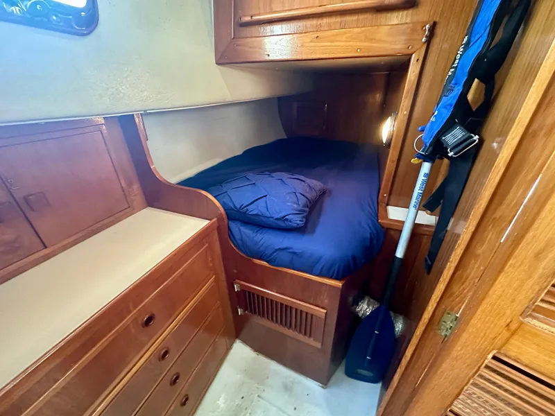 Slide: The Image of Cozy cabin interior of 1985 Fisher 34 Pilothouse Ketch with wooden furnishings and blue bedding. - 47