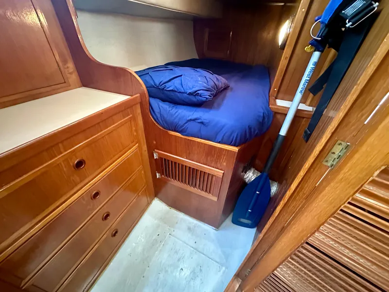 Slide: The Image of Cozy cabin interior of 1985 Fisher 34 Pilothouse Ketch with wooden furnishings and blue bedding. - 48