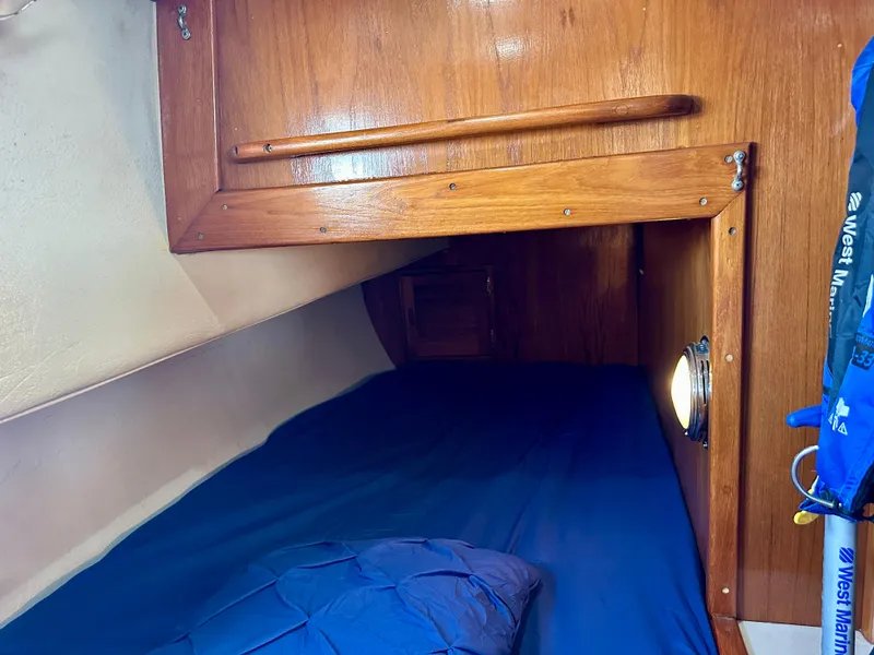 Slide: The Image of Cozy cabin interior of 1985 Fisher 34 Pilothouse Ketch with wooden finish and blue bedding. - 49