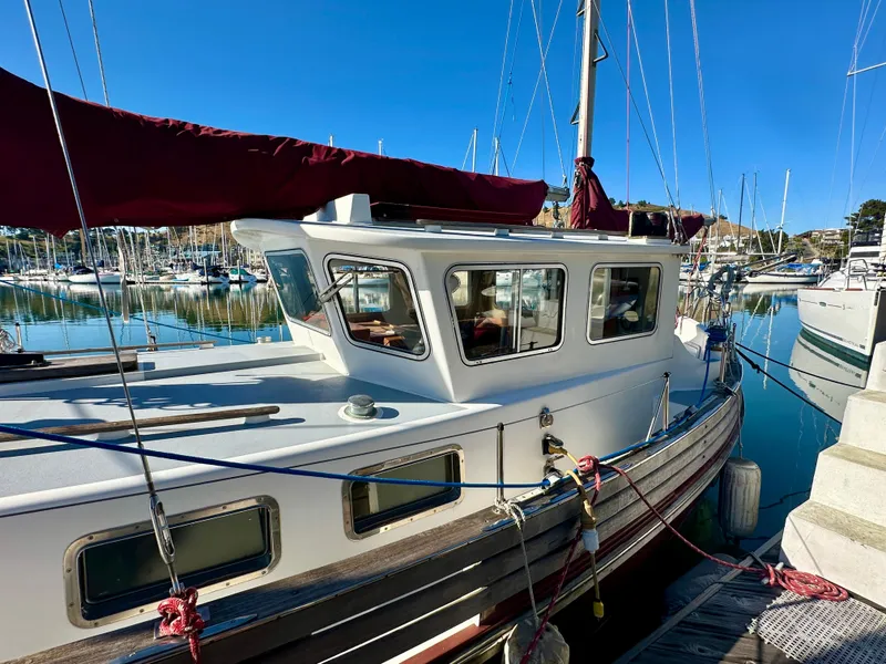 Slide: The Image of 1985 Fisher 34 Pilothouse Ketch docked in a marina under clear blue skies. - 5
