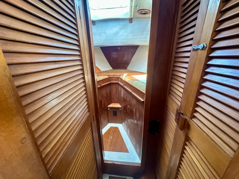 Slide: The Image of Interior view of 1985 Fisher 34 Pilothouse Ketch, featuring wooden cabinetry and cozy sleeping area. - 52
