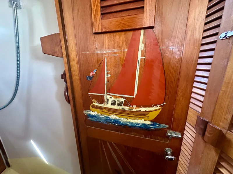 Slide: The Image of Wooden door with painted sailboat, Fisher 34 Pilothouse Ketch, 1985 model. - 54