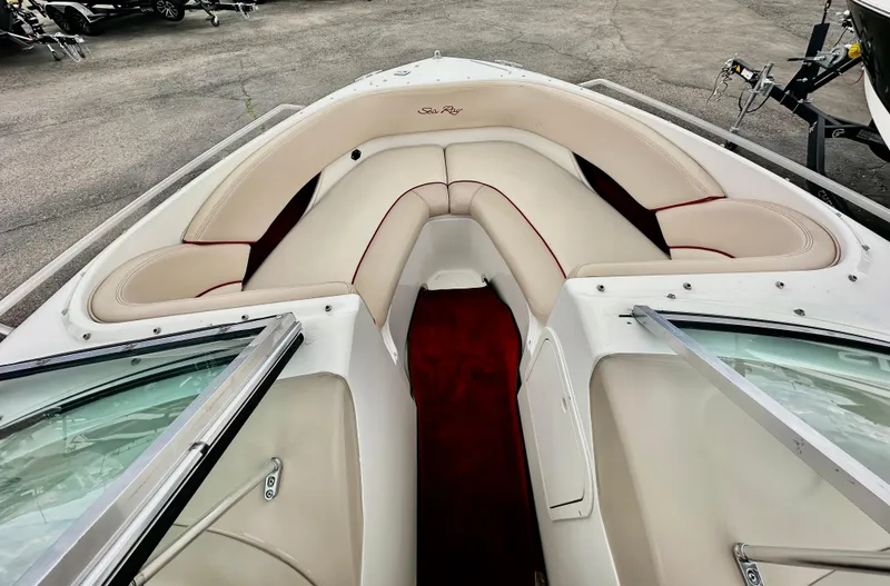 Slide: The Image of 1997 Sea Ray 210 Signature boat interior with beige seating and red carpet. - 11