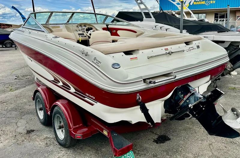Slide: The Image of 1997 Sea Ray 210 Signature boat on trailer, red and white design, parked outdoors. - 3