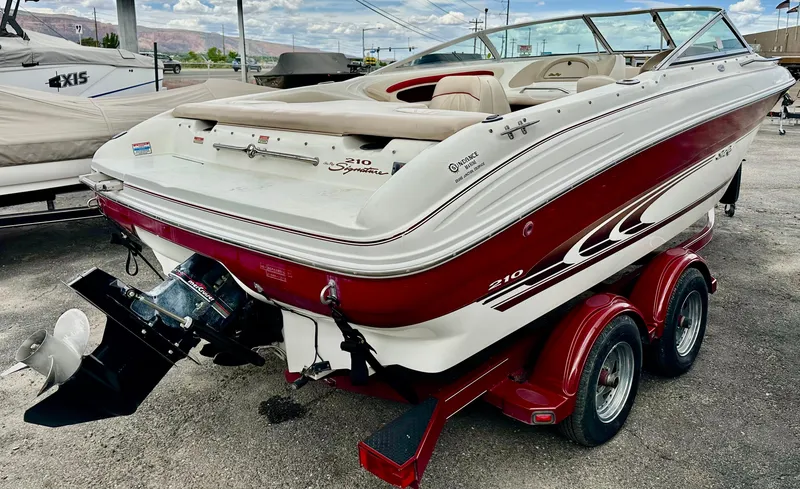 Slide: The Image of 1997 Sea Ray 210 Signature boat on trailer, red and white design, parked outdoors. - 4