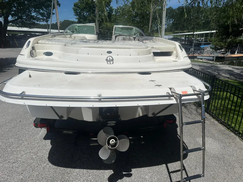 Slide: The Image of 2007 Bryant 240 boat rear view with ladder and propeller, parked on pavement. - 3