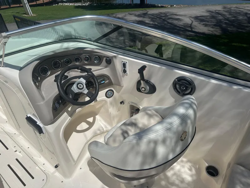 Slide: The Image of 2007 Bryant 240 boat interior with white cushioned seating and built-in speakers. - 4