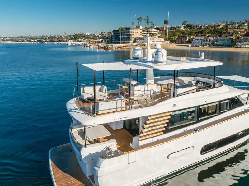 Slide: The Image of 2023 Azimut Magellano 66 yacht docked in a scenic coastal marina. - 12