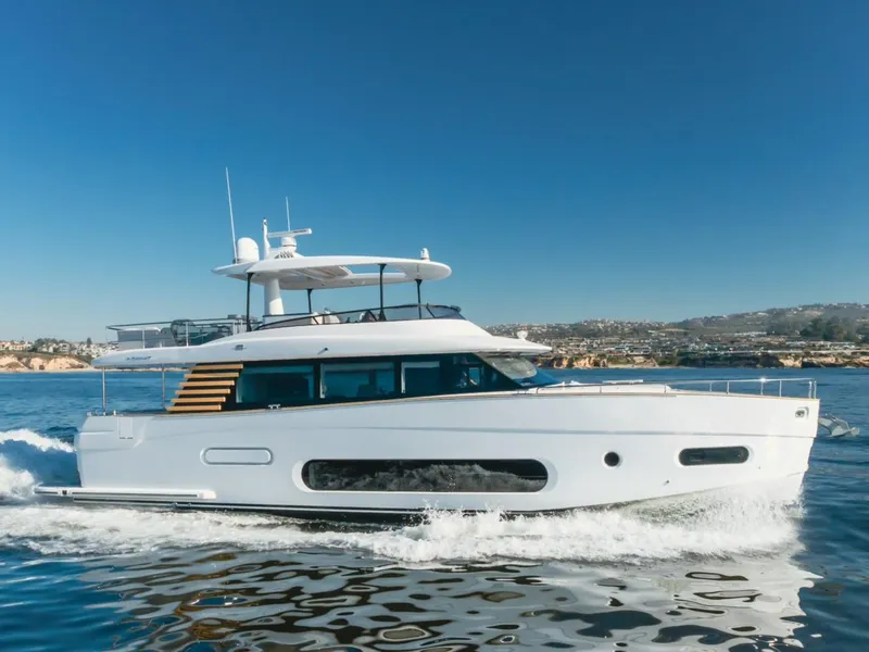 Slide: The Image of 2023 Azimut Magellano 66 yacht cruising on open water under clear blue skies. - 14