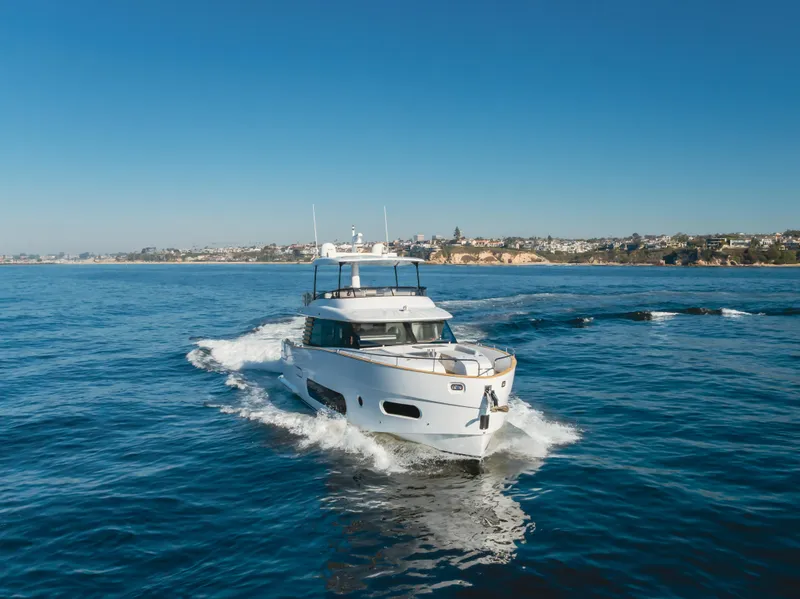 Slide: The Image of 2023 Azimut Magellano 66 yacht cruising on open water under clear blue skies. - 16