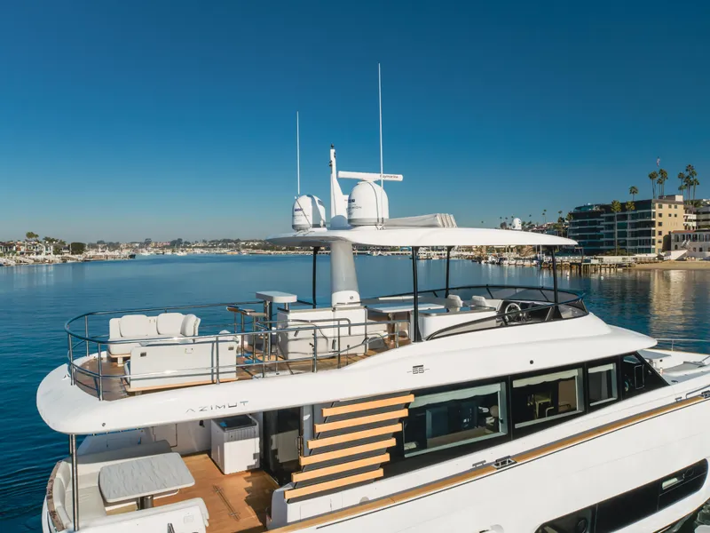 Slide: The Image of 2023 Azimut Magellano 66 yacht on calm waters, showcasing luxury design and spacious deck. - 3