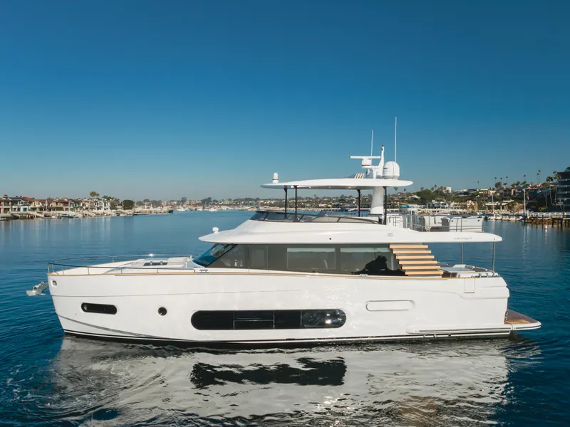 Slide: The Image of 2023 Azimut Magellano 66 yacht cruising on calm waters under clear blue skies. - 7