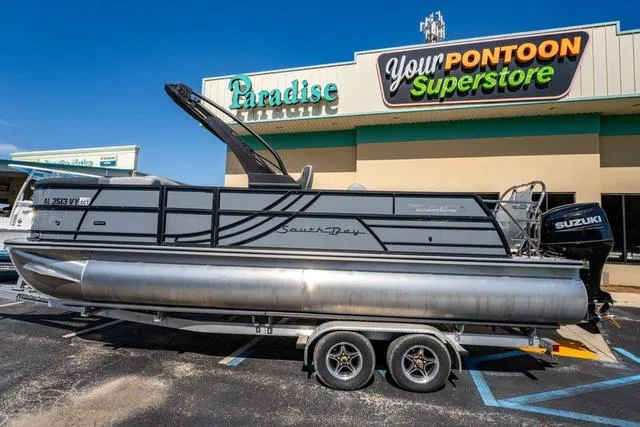 Slide: The Image of 2024 South Bay S224 UL 3.0 pontoon boat parked at a dealership. - 2