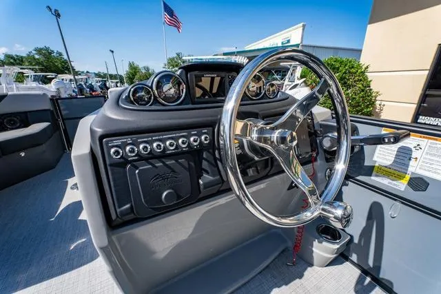 Slide: The Image of 2024 South Bay S224 UL 3.0 boat dashboard with steering wheel and control panel. - 24
