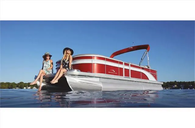 Slide: The Image of 2022 Bennington 22 SXFAPG pontoon boat on water with two people relaxing. - 24