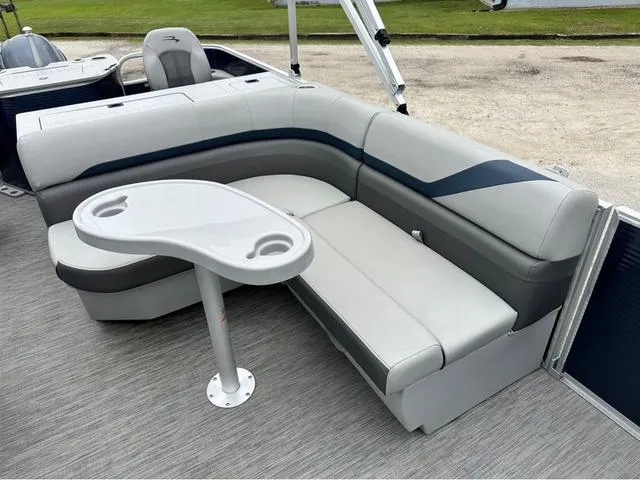 Slide: The Image of 2022 Bennington 22 SXFAPG boat interior with gray seating and a small table. - 9