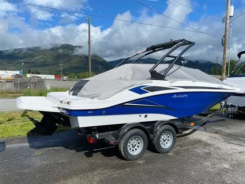 Slide: The Image of 2022 Hurricane SunDeck Sport 205 IO boat on trailer, scenic mountain backdrop. - 2