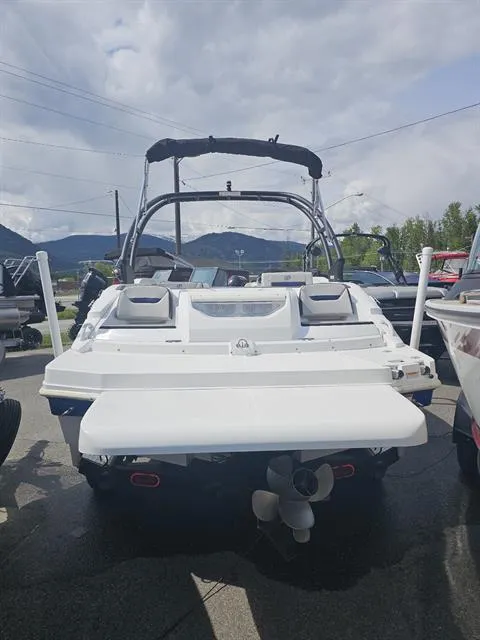 Slide: The Image of 2022 Hurricane SunDeck Sport 205 IO boat, rear view, parked outdoors under cloudy sky. - 20