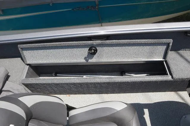 Slide: The Image of 2018 Lund 1875 Impact SC boat interior storage compartment with gray seating. - 12