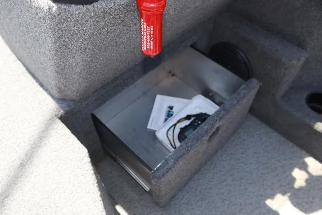 Slide: The Image of Storage compartment in a 2018 Lund 1875 Impact SC boat, containing documents and accessories. - 17