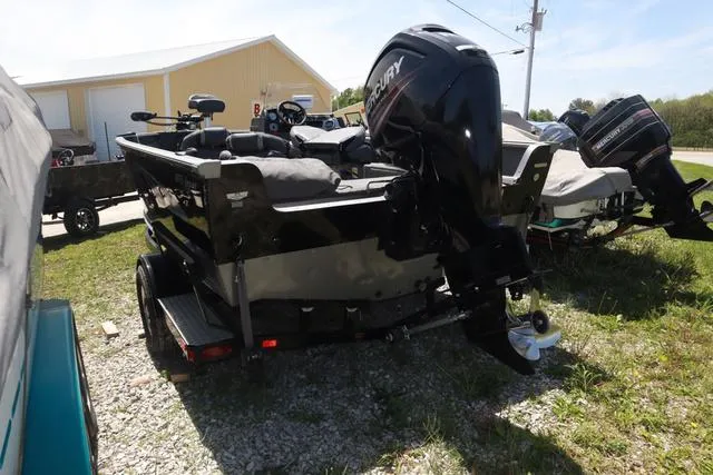 Slide: The Image of 2018 Lund 1875 Impact SC boat with Mercury outboard motor, parked on grass. - 4