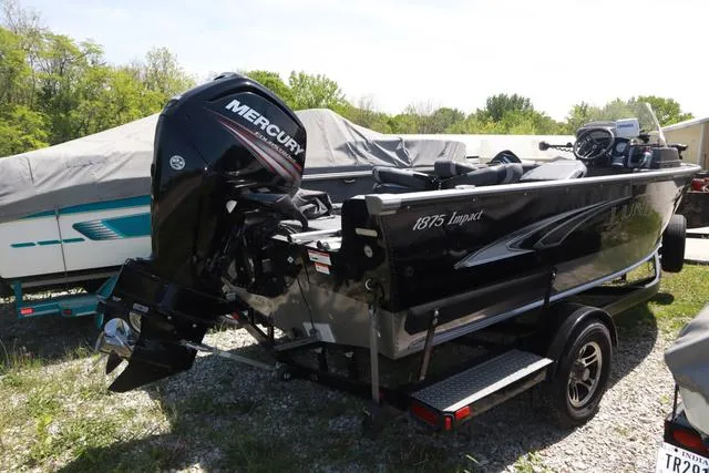 Slide: The Image of 2018 Lund 1875 Impact SC boat with Mercury outboard motor, parked on a trailer. - 5