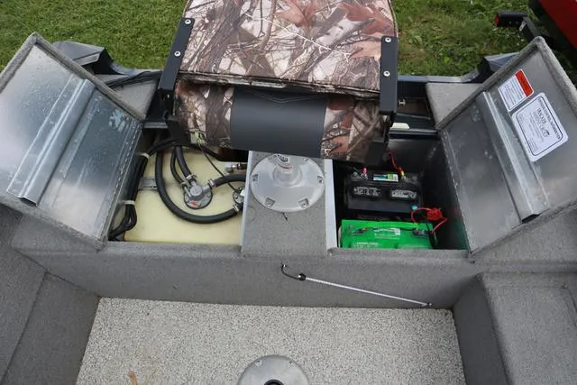 Slide: The Image of 2013 Tracker Super Guide V-16 SC boat interior with storage compartments and camo seat. - 13
