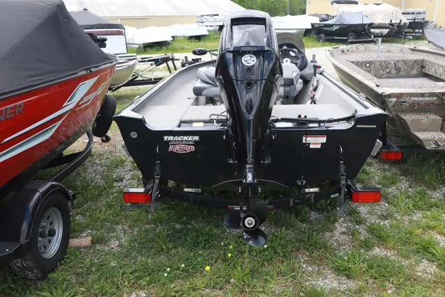Slide: The Image of 2013 Tracker Super Guide V-16 SC boat, rear view, parked on grass. - 3