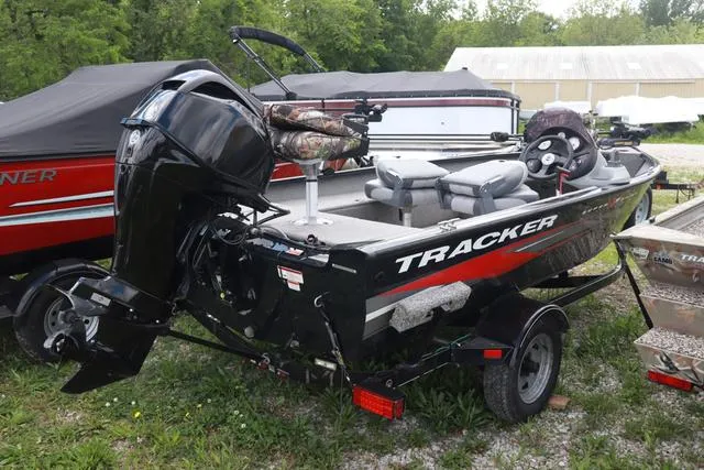 Slide: The Image of 2013 Tracker Super Guide V-16 SC boat with motor, parked outdoors. - 4