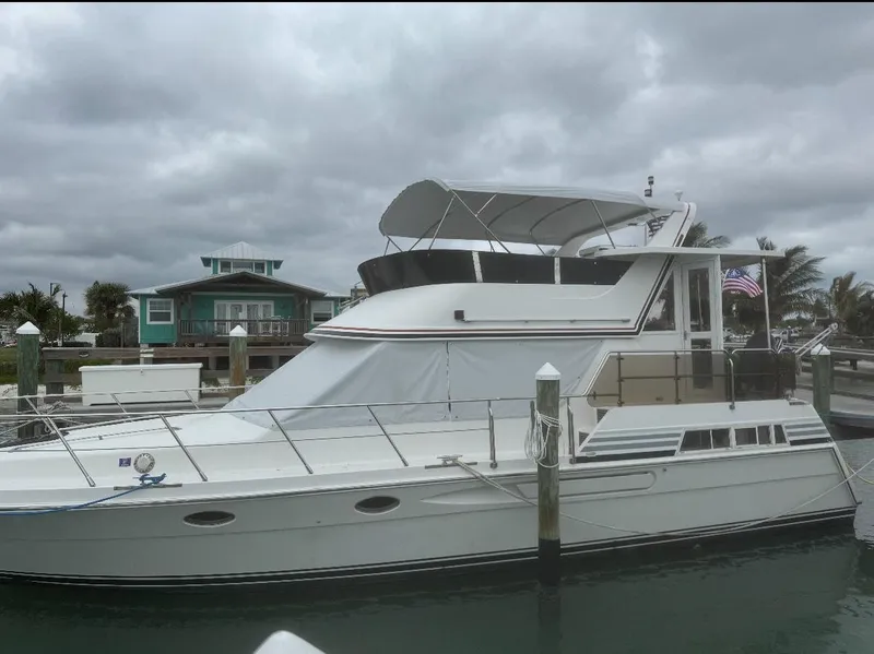 The Image of 1994 President 445 Sundeck yacht docked by waterfront homes. - 0