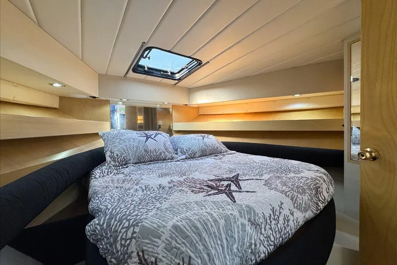 Slide: The Image of Cozy bedroom interior of 1994 President 445 Sundeck yacht with nautical-themed bedding. - 100