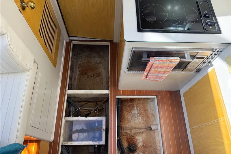 Slide: The Image of 1994 President 445 Sundeck interior with open floor hatch and kitchen appliances. - 109