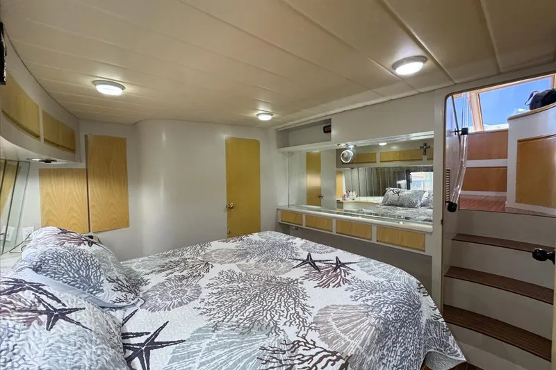 Slide: The Image of Cozy bedroom interior of 1994 President 445 Sundeck yacht with nautical-themed bedding. - 119