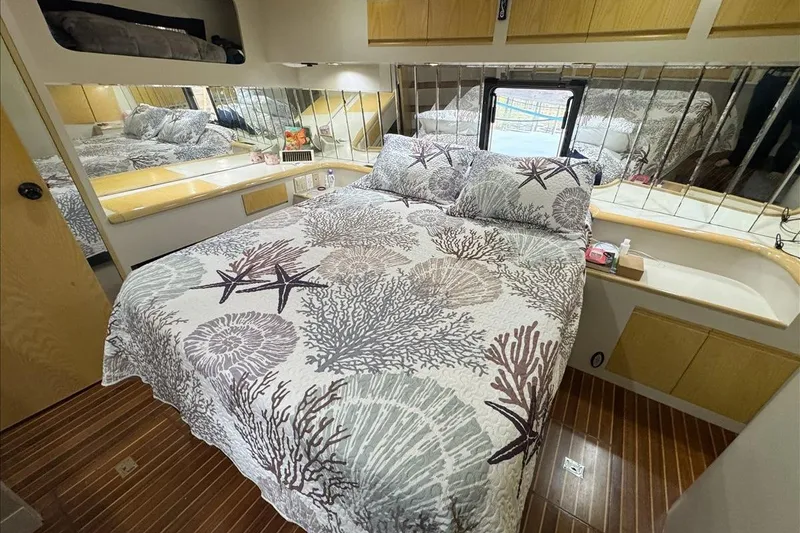 Slide: The Image of Cozy bedroom in 1994 President 445 Sundeck yacht with nautical-themed bedding and mirrored walls. - 120