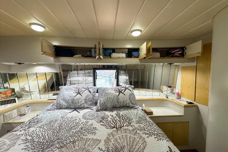 Slide: The Image of Cozy bedroom in 1994 President 445 Sundeck yacht with nautical-themed bedding and ample storage. - 125