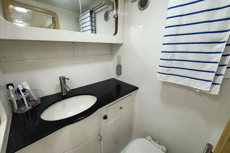 Slide: The Image of Bathroom interior of 1994 President 445 Sundeck yacht with sink and striped towel. - 133
