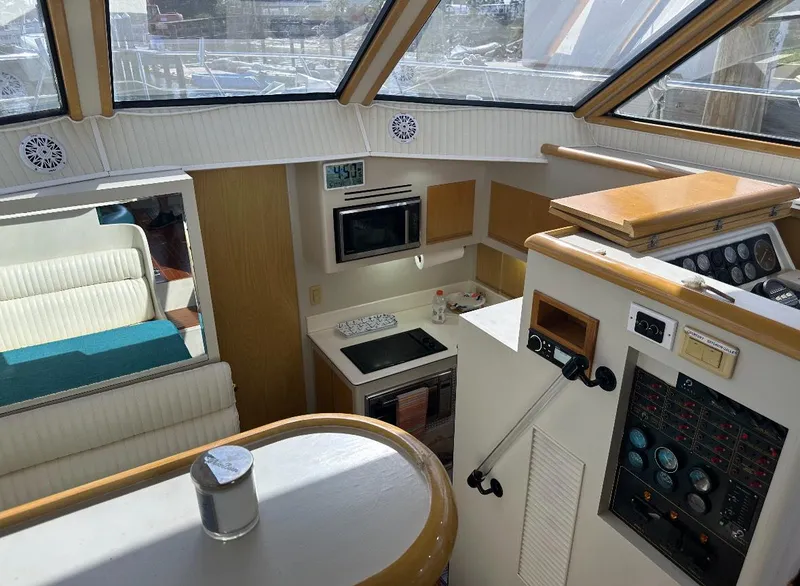 Slide: The Image of 1994 President 445 Sundeck yacht interior with chairs and stairs, docked near waterfront homes. - 16