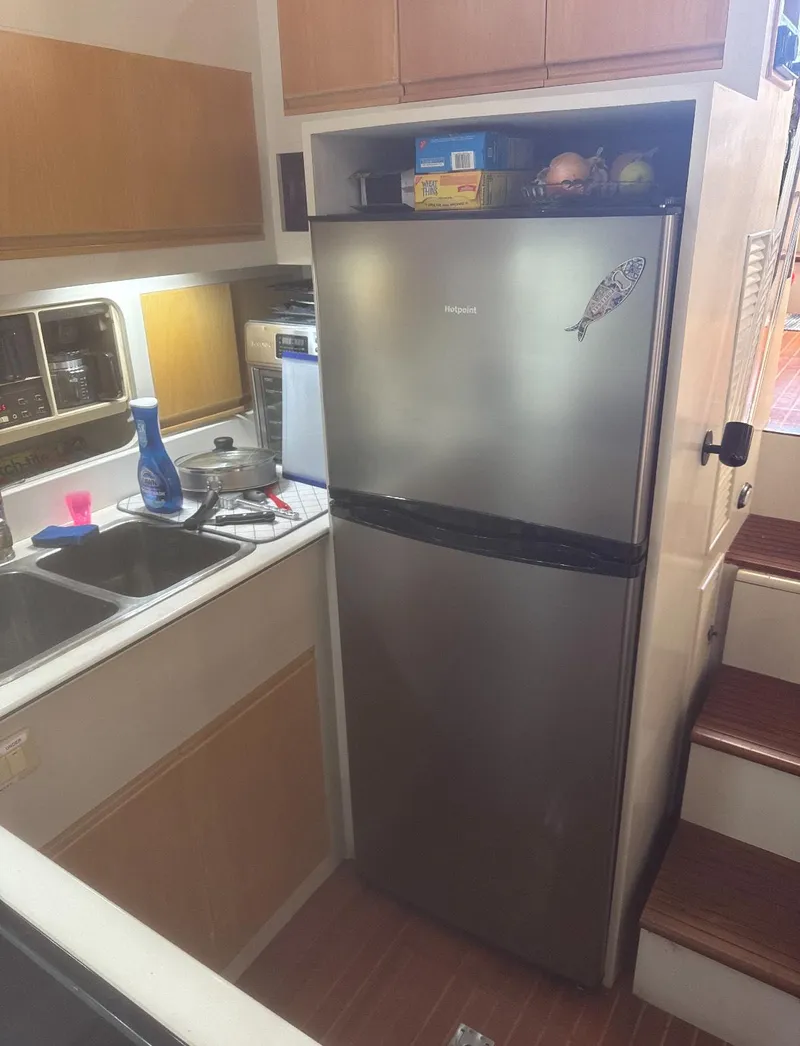 Slide: The Image of Cockpit of 1994 President 445 Sundeck yacht with steering wheel and controls, docked at marina. - 23