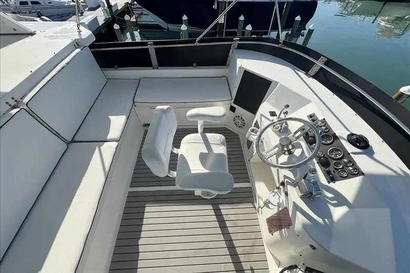 Slide: The Image of 1994 President 445 Sundeck yacht helm with white seating and control panel. - 37