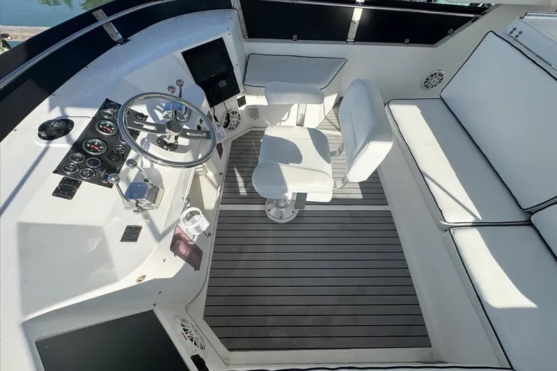 Slide: The Image of 1994 President 445 Sundeck yacht helm with white seating and control panel. - 40