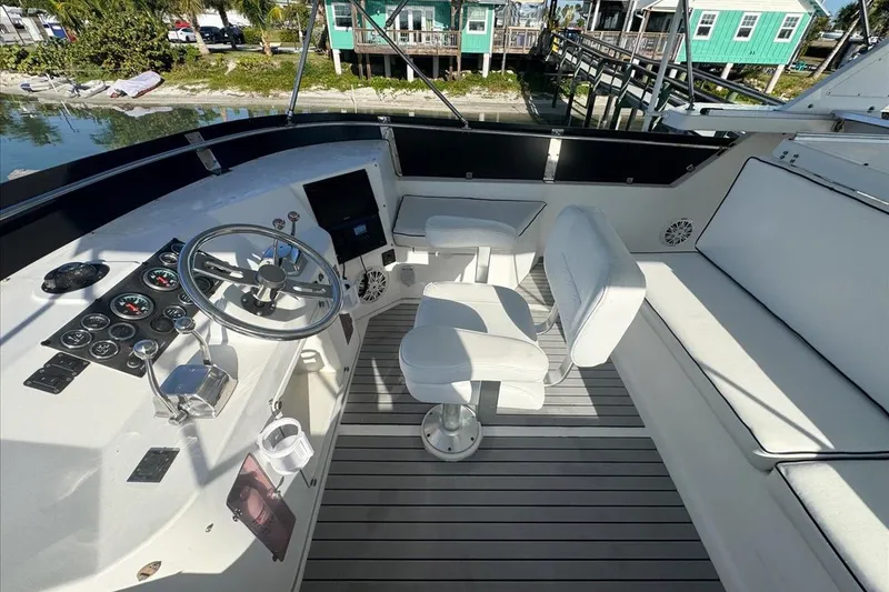 Slide: The Image of 1994 President 445 Sundeck yacht helm with white seating and control panel. - 41